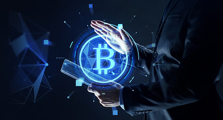 Image showing businessman with tablet pc and bitcoin hologram