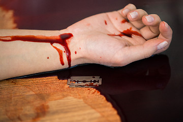 Image showing dead woman hand in blood on floor at crime scene