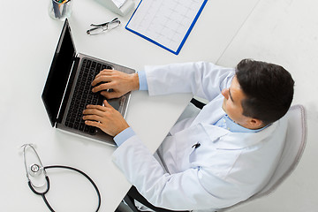 Image showing doctor with cardiogram and laptop at clinic