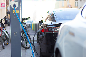 Image showing Charging modern electric car on the street as future of automotive industry.