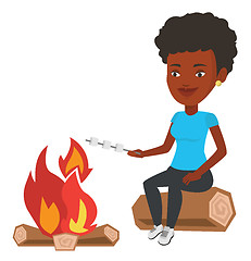 Image showing Woman roasting marshmallow over campfire.