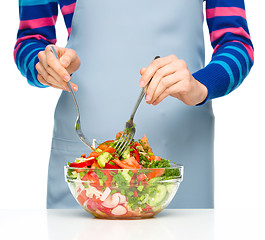 Image showing Cook is mixing salad