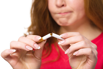 Image showing Young woman is breaking a cigarette