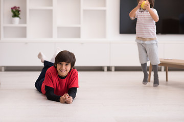 Image showing boys having fun with an apple on the floor