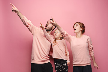Image showing Surprised young family on pink