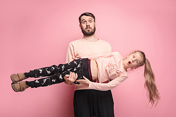 Image showing cheerful father playing with daughter on pink