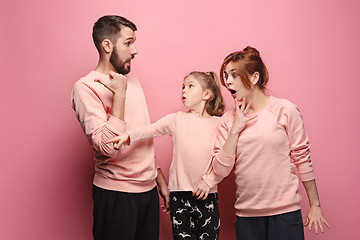 Image showing Surprised young family on pink