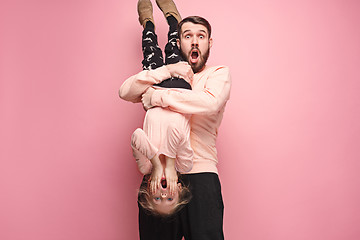 Image showing cheerful father playing with daughter on pink