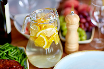 Image showing glass jug of lemon water and food on table