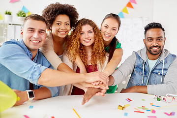 Image showing happy business team at office party holding hands