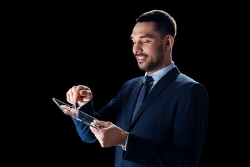 Image showing businessman in suit with transparent tablet pc