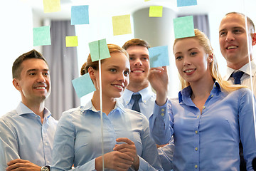 Image showing business team at glass wall with sticky notes