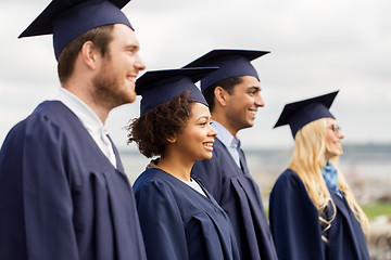 Image showing happy students or bachelors in mortar boards