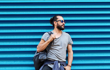 Image showing man in sunglasses with bag standing at street wall