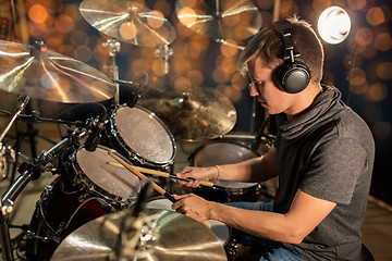 Image showing musician playing drum kit at concert over lights