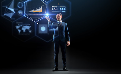 Image showing businessman working with charts on virtual screen