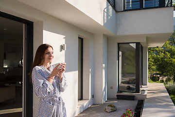 Image showing woman in a bathrobe enjoying morning coffee