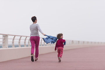 Image showing mother and cute little girl on the promenade by the sea