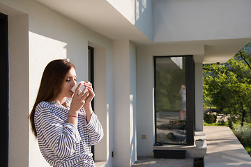 Image showing woman in a bathrobe enjoying morning coffee