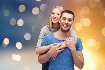 Image showing happy couple hugging over lights background