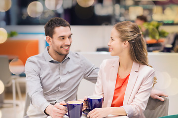 Image showing happy couple with shopping bags drinking coffee