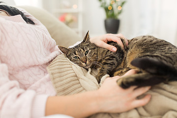 Image showing close up of owner with tabby cat in bed at home