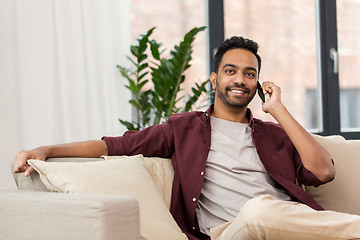 Image showing happy man calling on smartphone at home