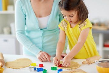 Image showing happy mother and daughter making cookies at home