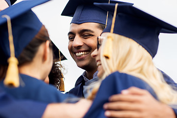 Image showing happy students or bachelors in mortar boards