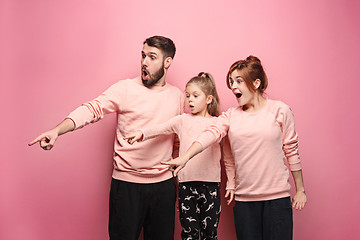 Image showing Surprised young family on pink