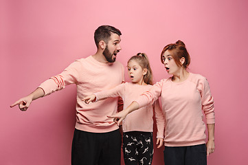 Image showing Surprised young family on pink