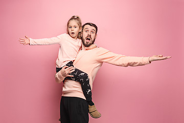 Image showing cheerful father playing with daughter on pink