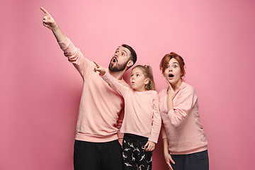 Image showing Surprised young family on pink