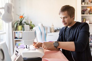 Image showing fashion designer with sewing machine at studio