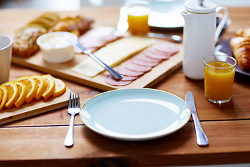 Image showing plate and glass of orange juice on table with food