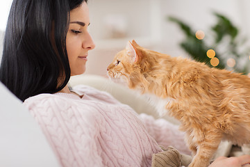 Image showing close up of owner with red cat in bed at home