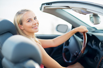 Image showing happy young woman driving convertible car