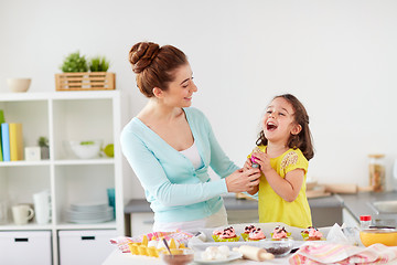 Image showing mother and daughter cooking cupcakes at home