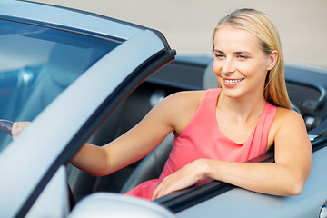 Image showing happy young woman driving convertible car