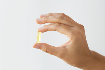 Image showing hand holding cod liver oil capsules