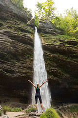 Image showing Active woman raising arms inhaling fresh air, feeling relaxed in nature.