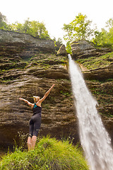 Image showing Active woman raising arms inhaling fresh air, feeling relaxed in nature.