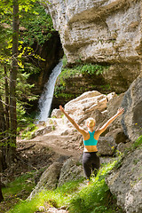 Image showing Active woman raising arms inhaling fresh air, feeling relaxed in nature.