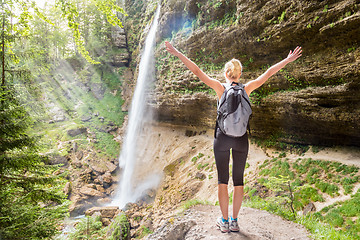 Image showing Active woman raising arms inhaling fresh air, feeling relaxed in nature.