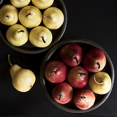 Image showing Several yellow and red pears in bowls