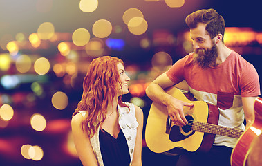 Image showing couple of musicians playing guitar over lights