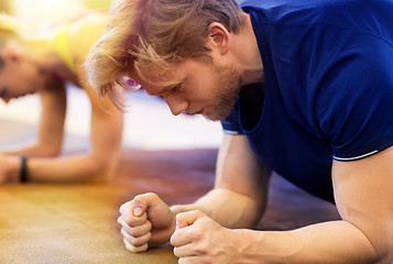 Image showing close up of man at training doing plank in gym