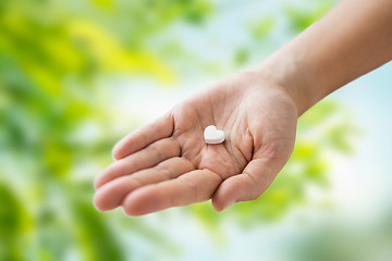 Image showing close up of hand holding medicine heart pill