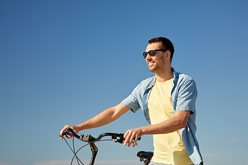 Image showing happy smiling man with bicycle outdoors