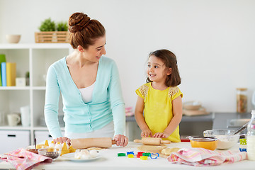 Image showing happy mother and daughter making cookies at home